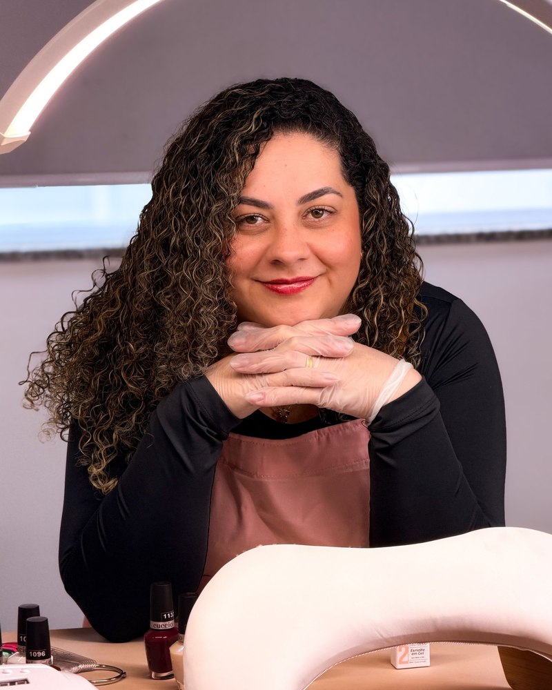 Natália Canelhas, manicure da NRB Nails, sorrindo no studio